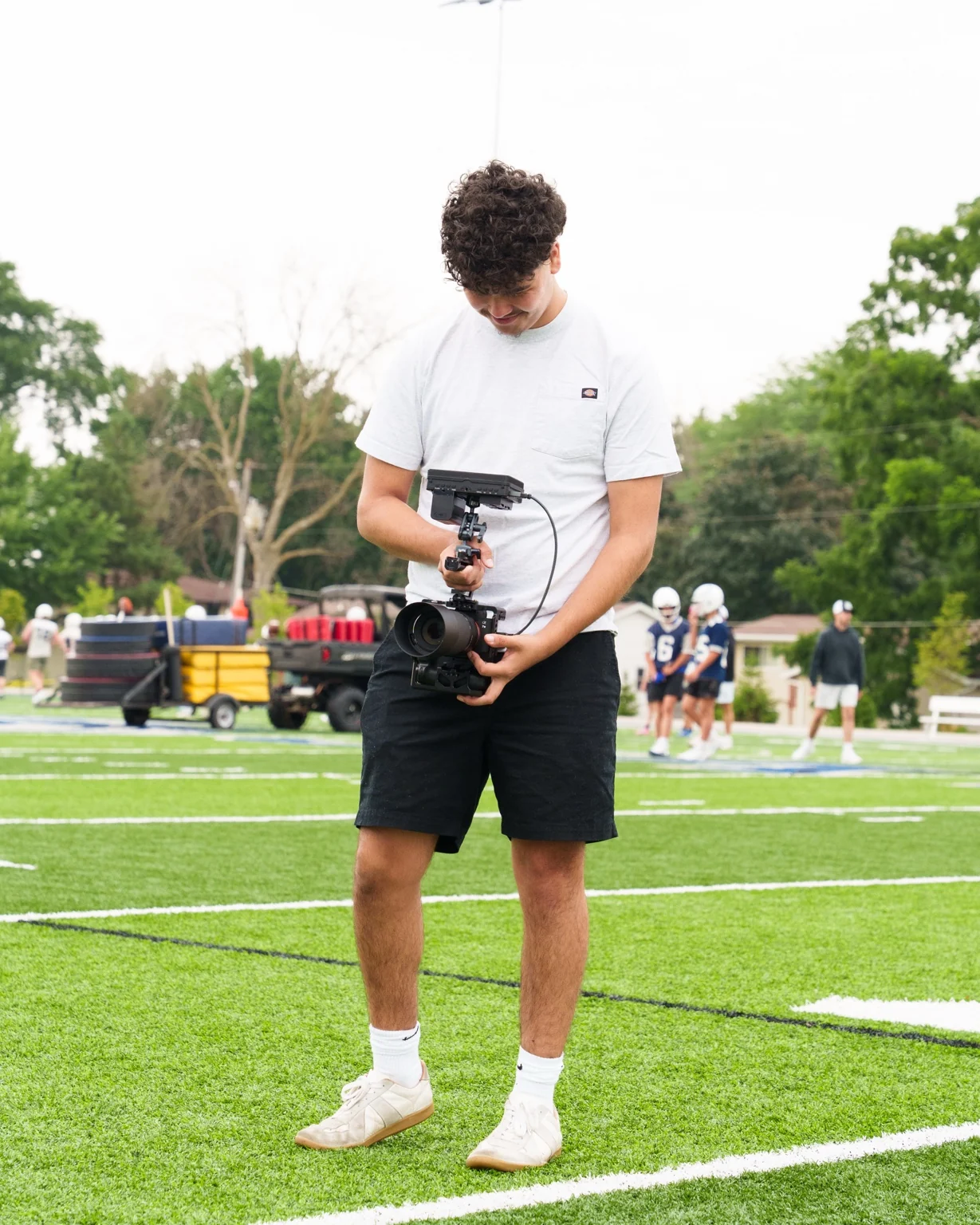 Carter Folts filming on a football field