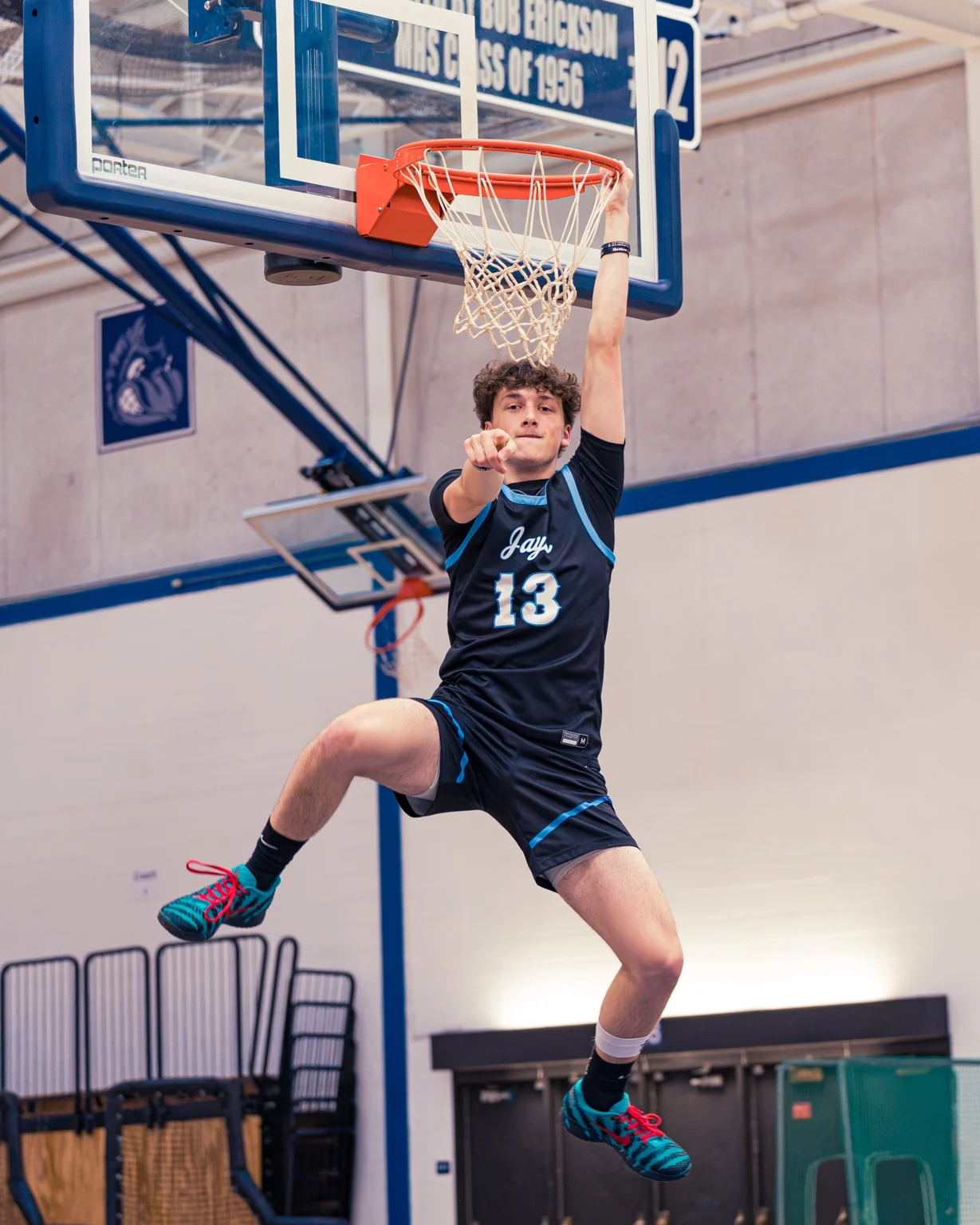 Basketball player hanging from the rim after a dunk